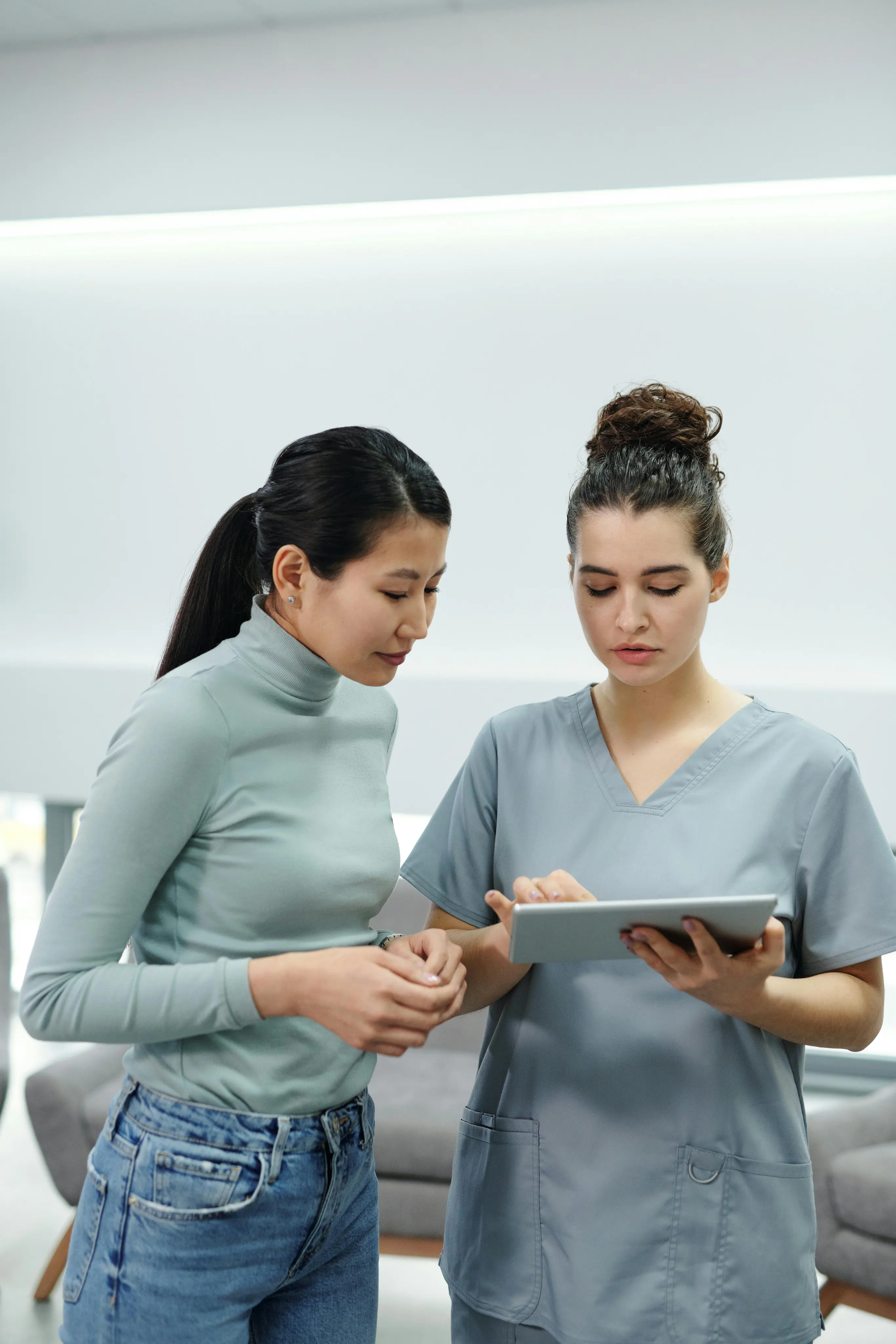 A clinic professional and colleague reviewing information on a tablet